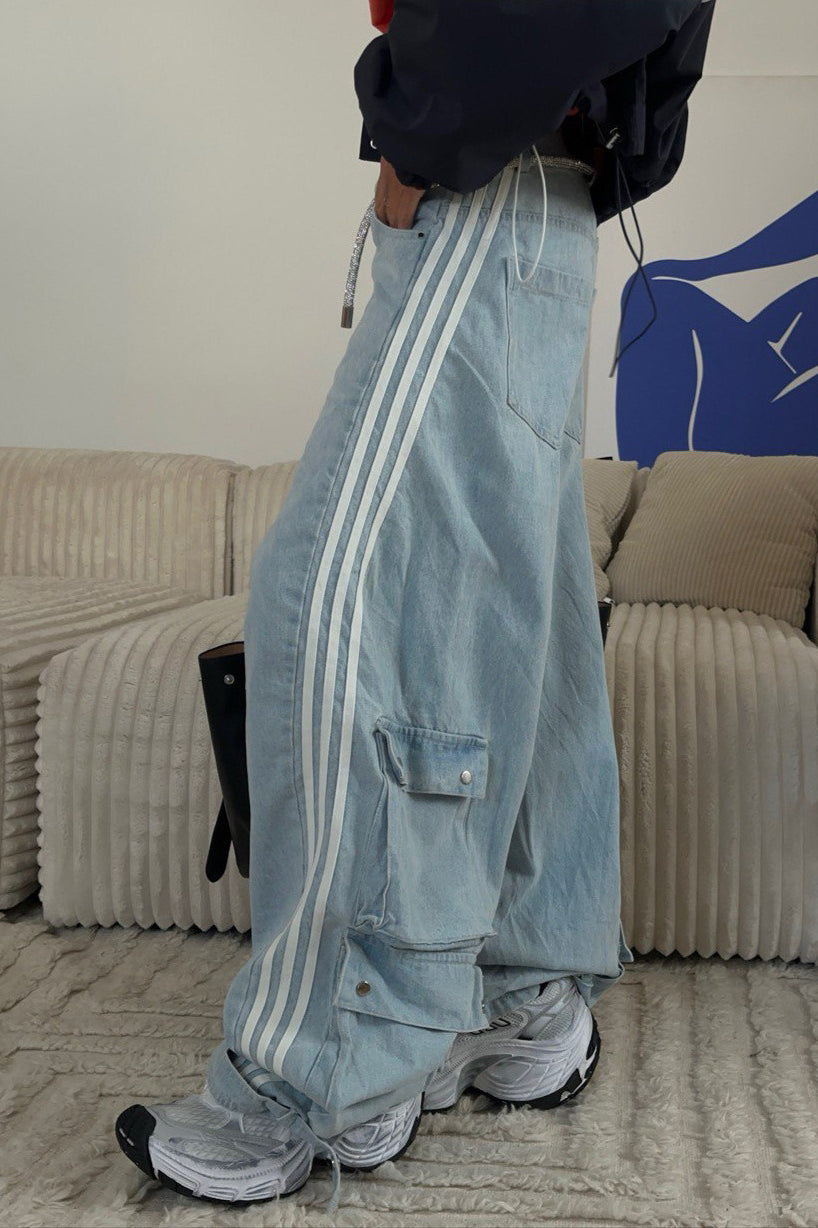 Damskie jeansy denim w paski ze szerokimi nogawkami, ujęcie z boku