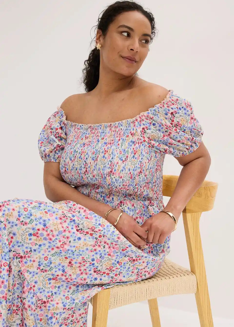 Damska sukienka midi w kwiaty off shoulder elegancko prezentowana na modelce