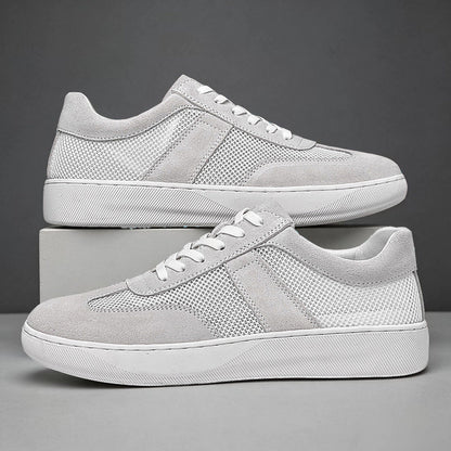 Profil kobaltowego sneakersa z siateczki i zamszu na jasnym tle
