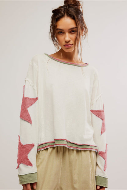 Detal aplikacji gwiazdy na rękawie bluzy oversize
