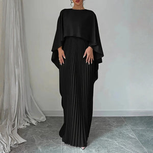 Elegancka sukienka maxi z peleryną prezentowana jako stylizacja weselna